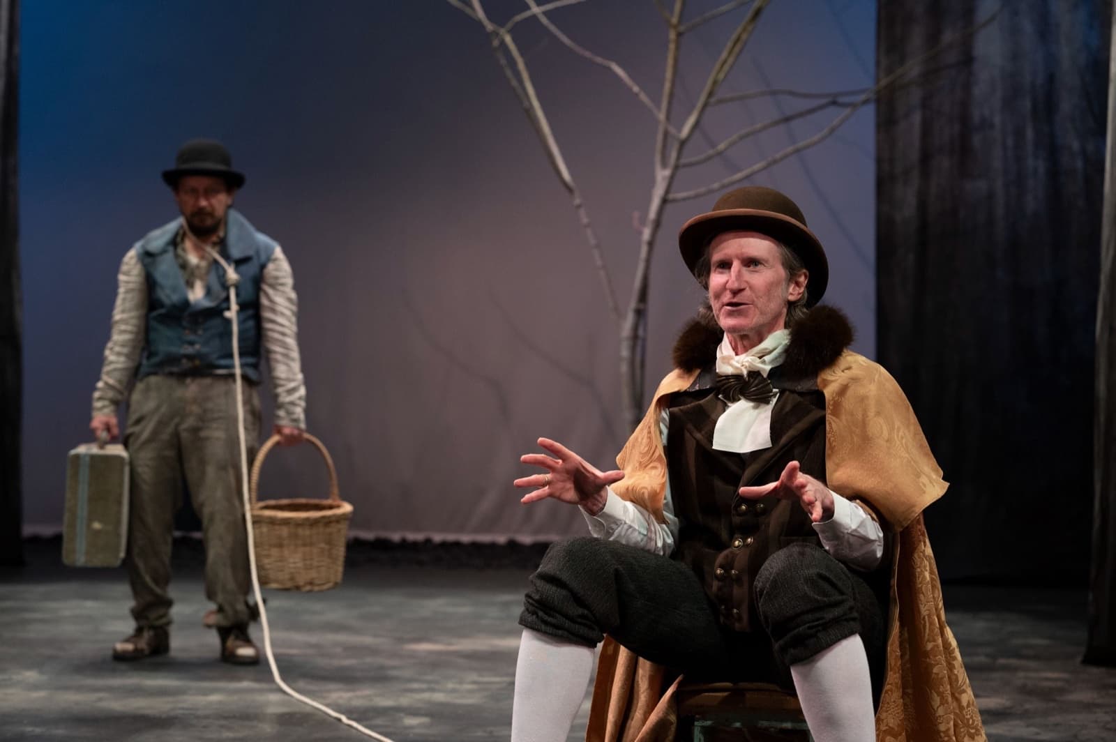 Pozzo gestures from his stool while Lucky stands behind holding the rope